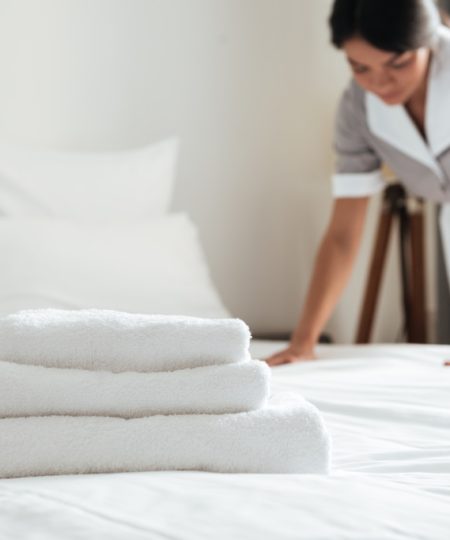young-hotel-maid-setting-up-pillow-bed.jpg